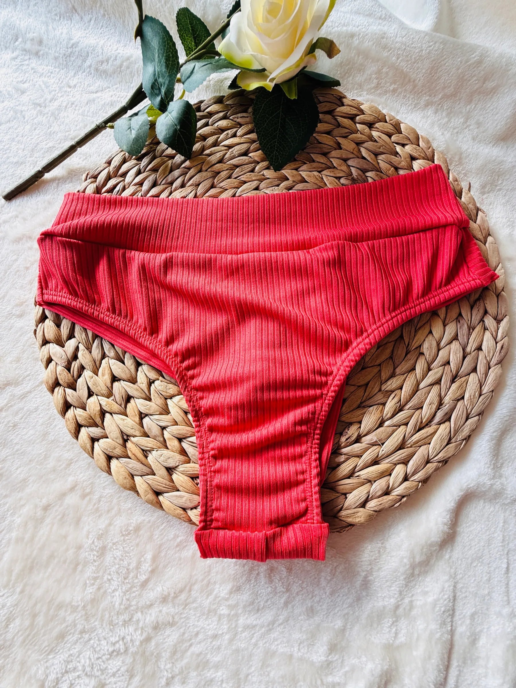 Kailani Ribbed bikini slip in coral pink van Shonnie Collection, geribde high-cut bikinibroek met comfortabele pasvorm en luxe flat-lay presentatie.